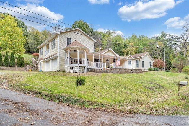 view of front of property featuring a garage, a front yard, and covered porch