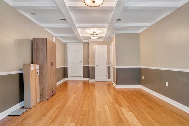 interior space with coffered ceiling, light hardwood / wood-style floors, and beam ceiling