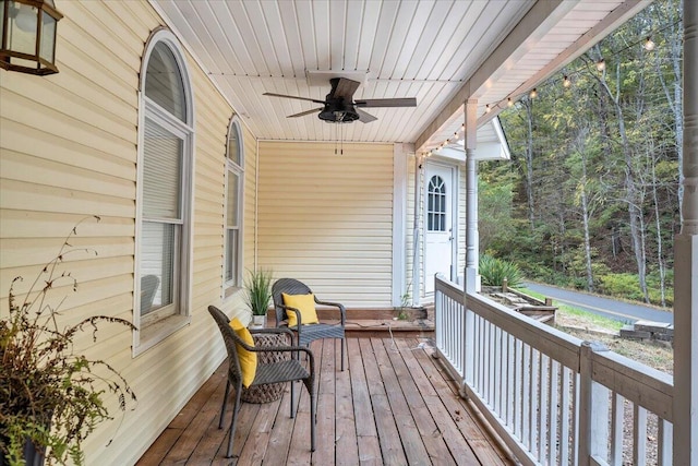 wooden deck featuring a porch and ceiling fan