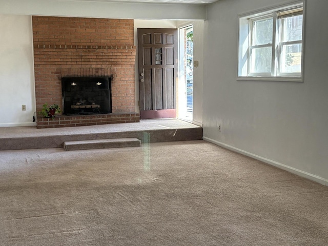 unfurnished living room with carpet flooring and a brick fireplace