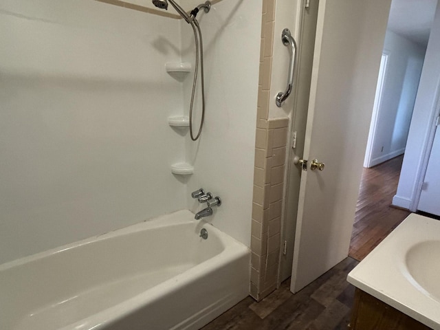 bathroom featuring wood-type flooring, vanity, and tub / shower combination