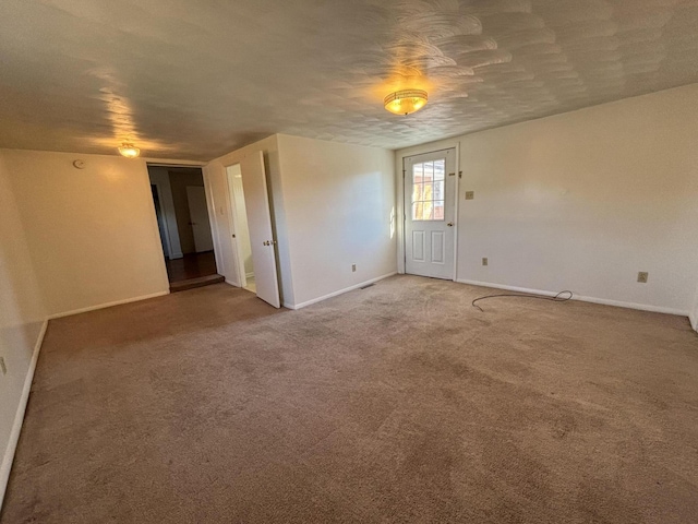 empty room featuring a textured ceiling and carpet floors