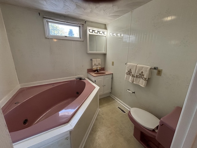 bathroom featuring a bathing tub, vanity, and toilet