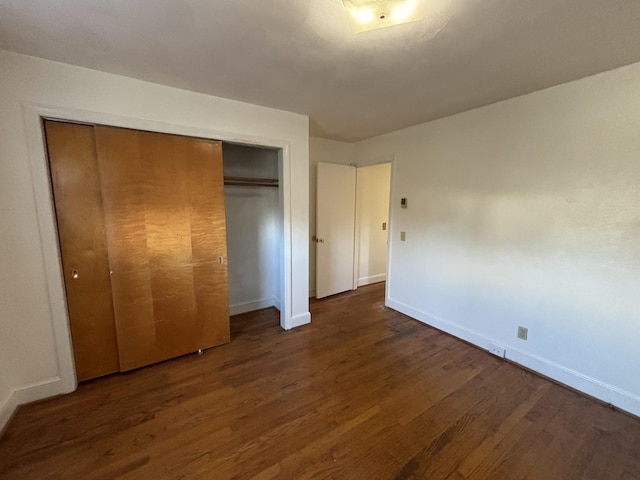 unfurnished bedroom with a closet and dark hardwood / wood-style floors