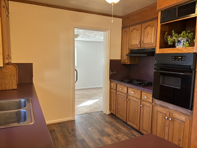 kitchen with black appliances, dark hardwood / wood-style floors, ornamental molding, and sink