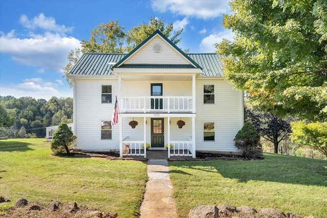 view of front facade with a balcony and a front lawn