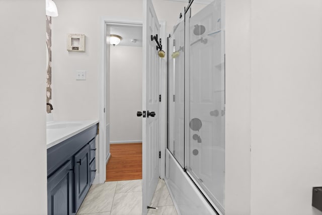 bathroom featuring hardwood / wood-style floors, combined bath / shower with glass door, and vanity