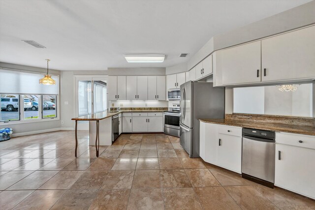 kitchen with pendant lighting, an inviting chandelier, white cabinetry, kitchen peninsula, and stainless steel appliances