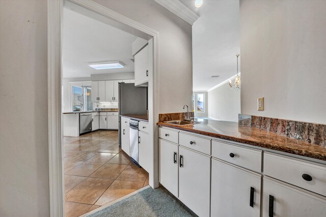 kitchen with white cabinetry, sink, ornamental molding, and appliances with stainless steel finishes