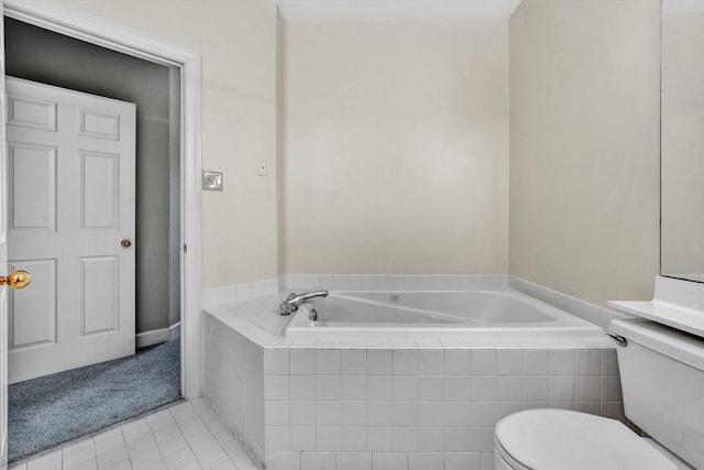 bathroom with tile patterned flooring, a relaxing tiled tub, and toilet