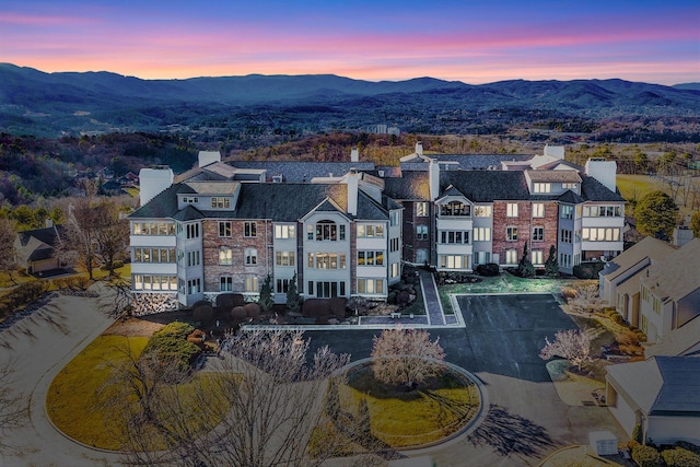 aerial view at dusk featuring a mountain view