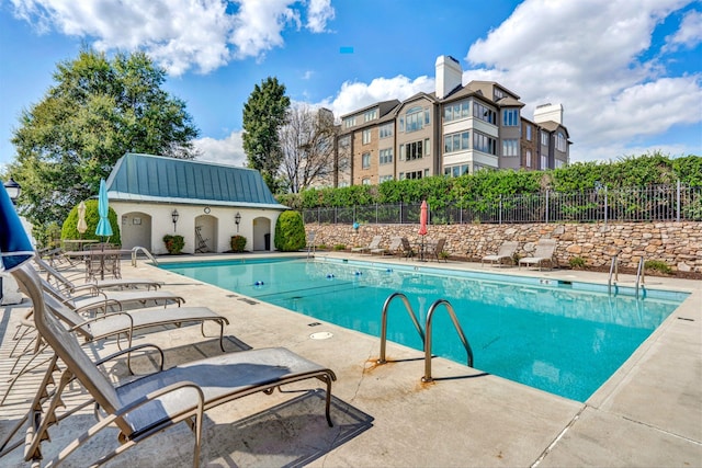 view of swimming pool with an outbuilding and a patio