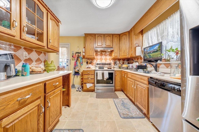 kitchen featuring light tile patterned floors, sink, appliances with stainless steel finishes, and tasteful backsplash