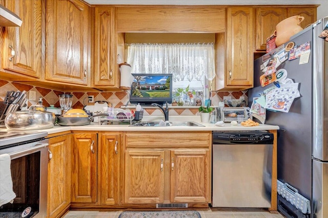 kitchen featuring tasteful backsplash, appliances with stainless steel finishes, light tile patterned floors, and exhaust hood