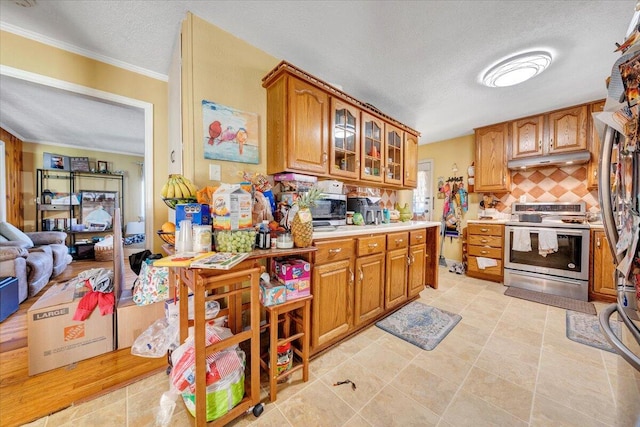 kitchen featuring tasteful backsplash, ornamental molding, appliances with stainless steel finishes, a textured ceiling, and light tile patterned floors