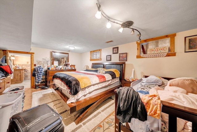 bedroom featuring light hardwood / wood-style floors and rail lighting