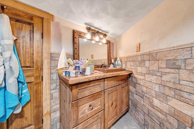 bathroom featuring vanity, a textured ceiling, and vaulted ceiling