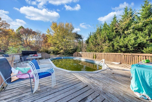 wooden deck with a fenced in pool