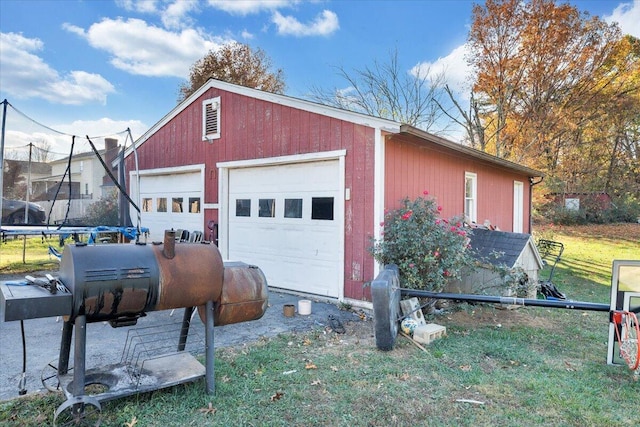 garage featuring a lawn and a trampoline