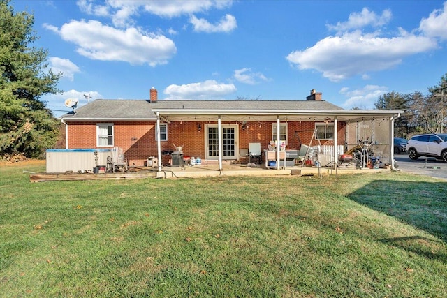 rear view of property featuring a lawn and a patio