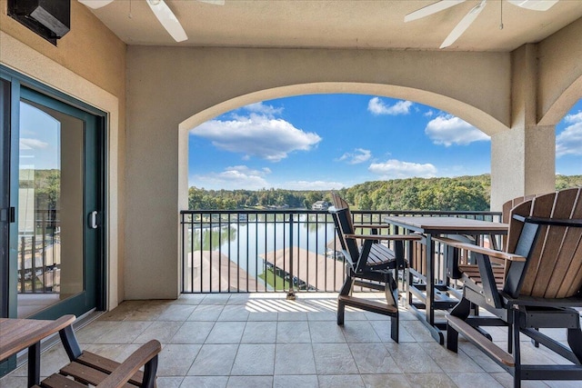 balcony with a water view and ceiling fan