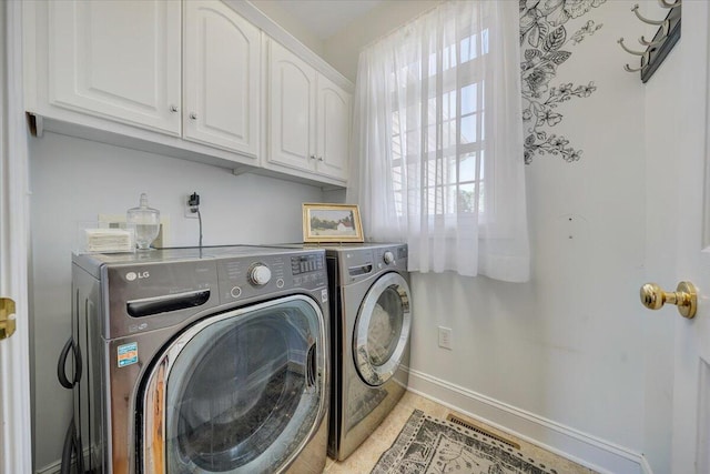 clothes washing area with washing machine and dryer and cabinets