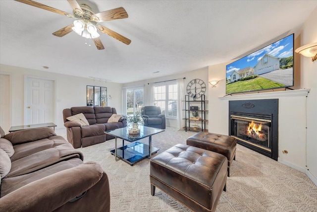 living room featuring ceiling fan, a textured ceiling, and light carpet