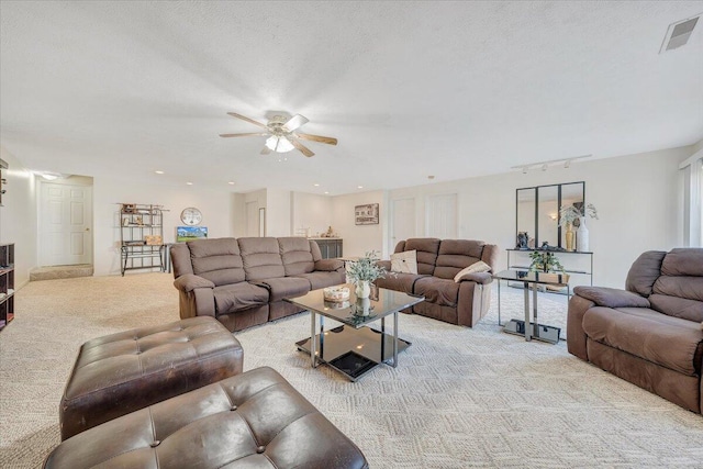 carpeted living room with ceiling fan and a textured ceiling