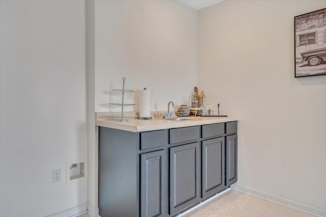 bar with sink and gray cabinetry