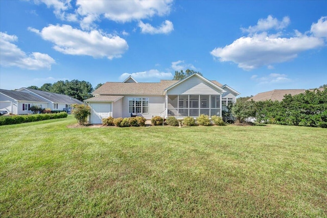 back of property with a yard, a sunroom, and a garage