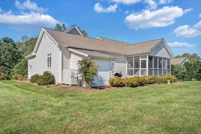 view of home's exterior with a garage, a sunroom, and a lawn