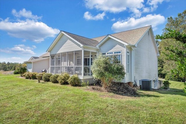 back of property with a sunroom, central air condition unit, and a lawn