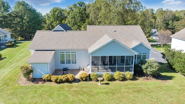 rear view of property featuring a sunroom and a lawn