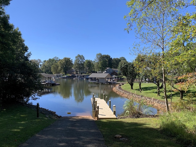 view of dock featuring a water view and a yard