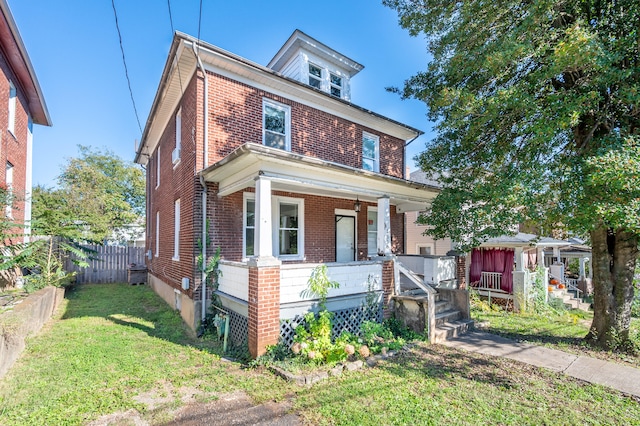 view of front of house with covered porch and a front yard