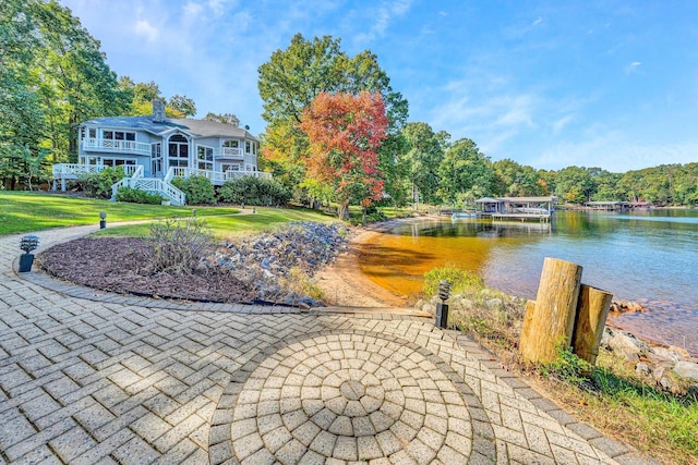 view of property's community with a yard and a water view