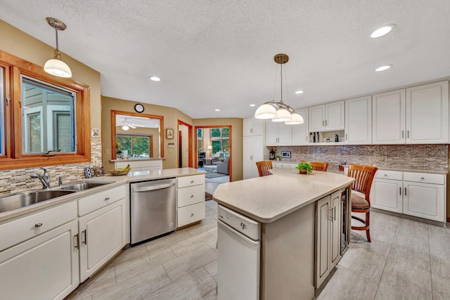 kitchen featuring dishwasher, a center island, decorative light fixtures, and white cabinetry