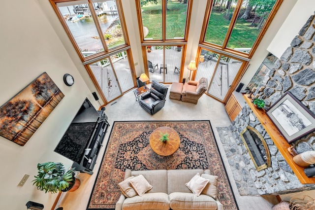 living room with a high ceiling and a fireplace