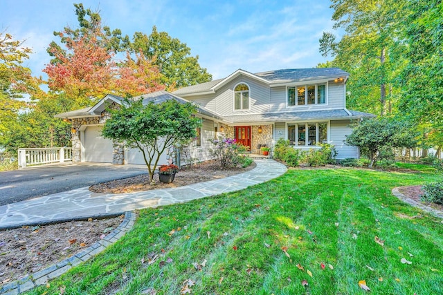 view of front of property with covered porch, a front yard, and a garage