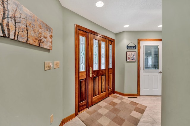 tiled entrance foyer featuring a textured ceiling