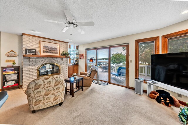 living room featuring a brick fireplace, light carpet, a textured ceiling, and ceiling fan