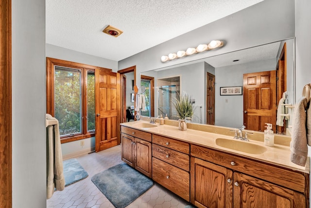 bathroom featuring vanity, a shower, tile patterned floors, and a textured ceiling