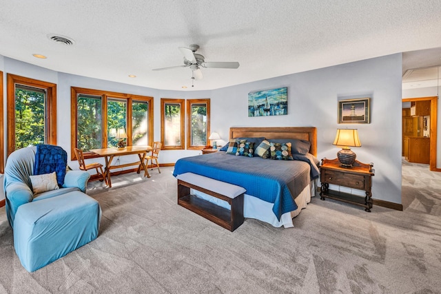 carpeted bedroom featuring multiple windows, a textured ceiling, and ceiling fan