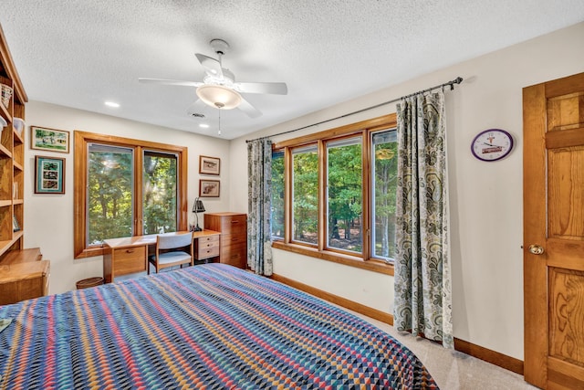 bedroom featuring ceiling fan, a textured ceiling, and light colored carpet