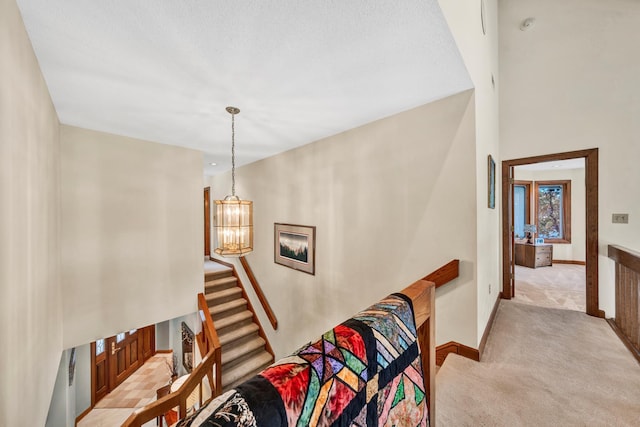 stairway featuring carpet floors and an inviting chandelier