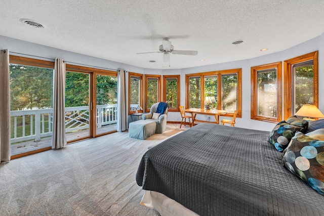 carpeted bedroom with ceiling fan, access to outside, and a textured ceiling