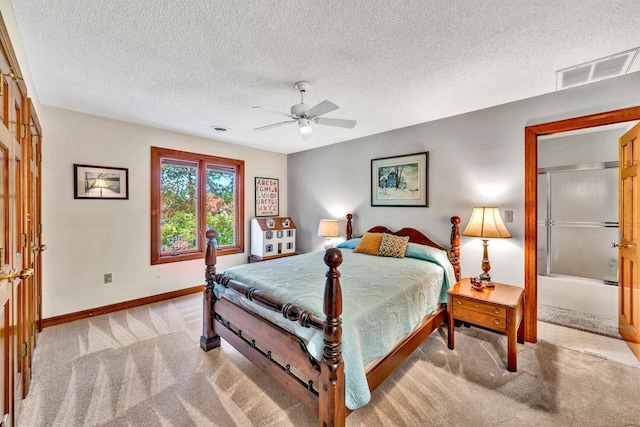 bedroom featuring a textured ceiling, light colored carpet, and ceiling fan