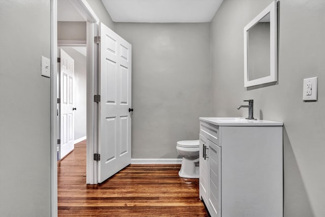 bathroom featuring vanity, toilet, and hardwood / wood-style flooring