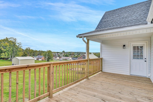 wooden terrace featuring a storage shed and a yard