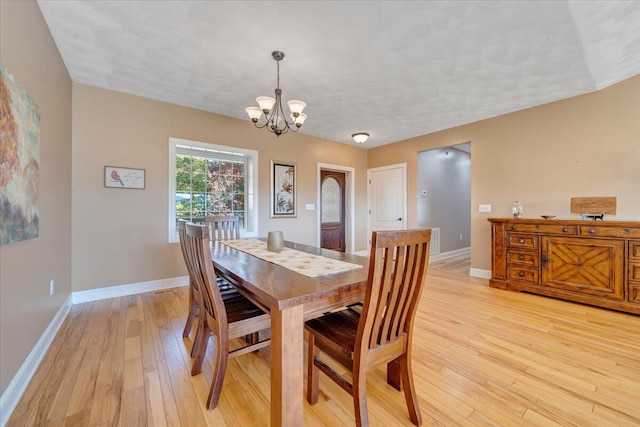 dining space featuring a notable chandelier and light hardwood / wood-style floors